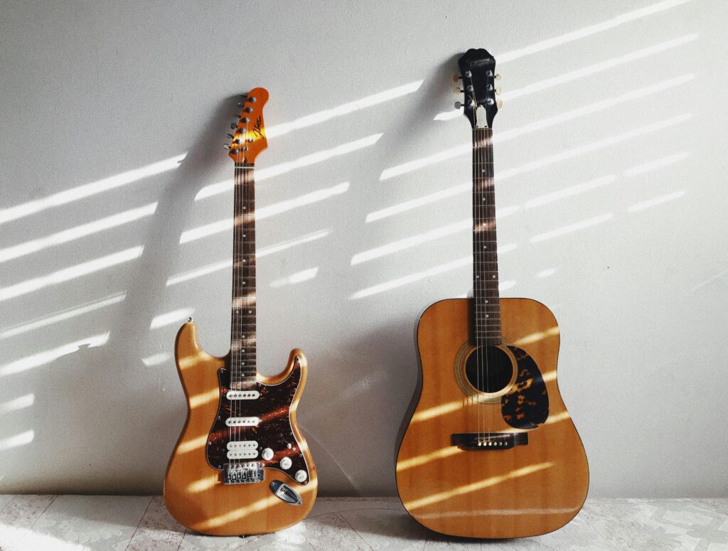 A minimalist scene featuring an acoustic and electric guitar against a white wall, perfect for music enthusiasts.