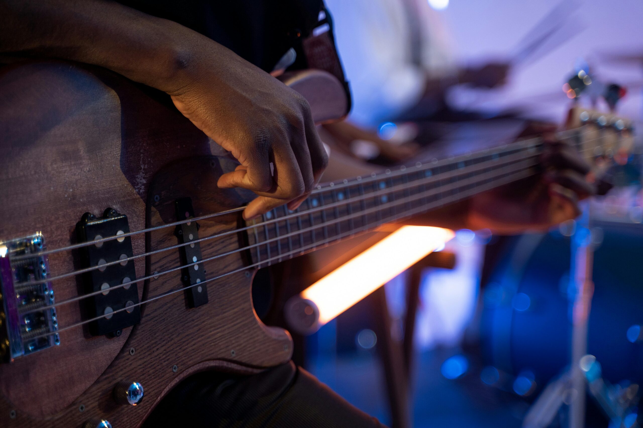 pexels-photo-8044197-8044197 Close-up of a musician strumming an electric bass guitar, showcasing musical expression.